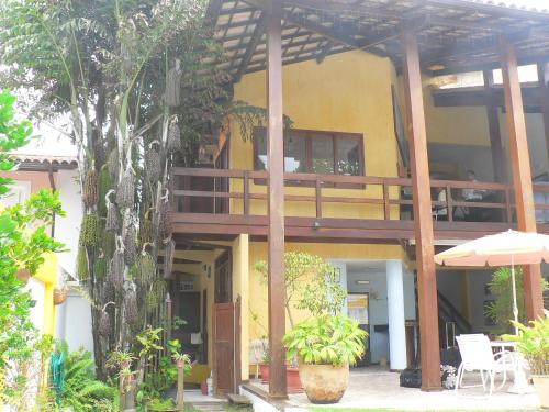 a building with a balcony with a table and an umbrella at Hotel Pousada Encanto de Itapoan in Salvador