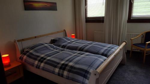1 dormitorio con 1 cama con manta de cuadros azul en Vakantiewoning Kleijnen en Noorbeek