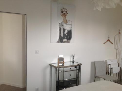 a bedroom with a bed and a picture on the wall at O Mylle Douceurs in Le Crotoy