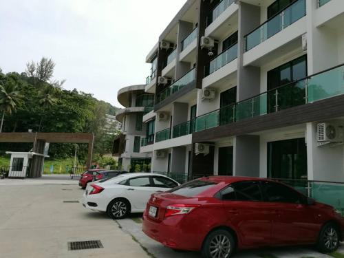 two cars parked in a parking lot in front of a building at The Naithorn Condo Unit 401 in Nai Thon Beach