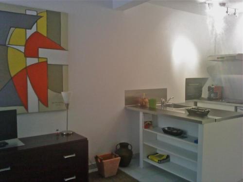 a room with a kitchen with a sink and a desk at Appartement coeur de ville in Ajaccio