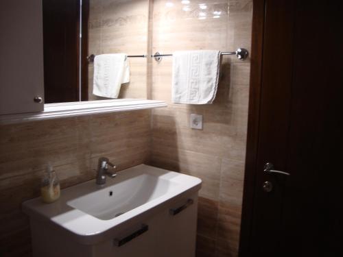 bagno con lavandino, specchio e asciugamani di Fantasia Apartment a Lákones