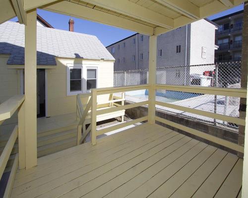 a wooden deck with a bench on a building at Shore Beach Houses - 38 C Lincoln Avenue in Seaside Heights