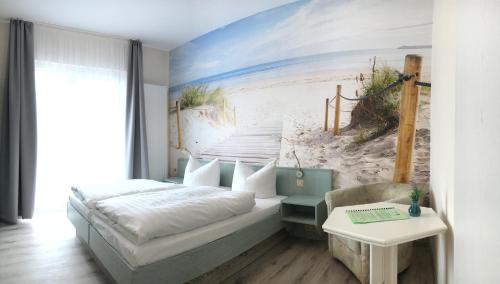 ein Schlafzimmer mit einem Bett und einem Wandbild vom Strand in der Unterkunft Kastanienhof Hotel garni in Zinnowitz