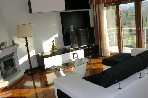 a living room with a fireplace and a tv at Quinta das Lindas 2 in Mondim de Basto