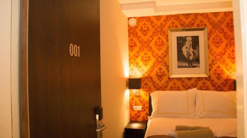 a bedroom with a bed and a picture on the wall at Royal Plaza Hotel Amsterdam in Amsterdam