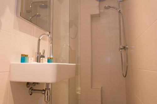 a bathroom with a sink and a shower at Royal Plaza Hotel Amsterdam in Amsterdam