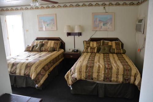 1 dormitorio con 2 camas y ventana en Budget Inn of Brownfield, en Brownfield