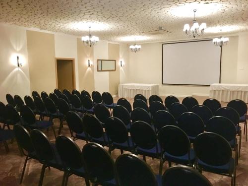 a conference room with chairs and a projection screen at Hotel Gryf in Kościerzyna