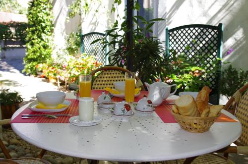 een witte tafel met ontbijtproducten erop bij hôtel la tour des fées in Quissac