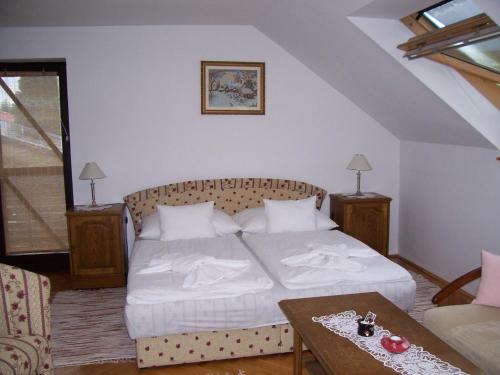 ザラカロシュにあるJúlia Vendégházのベッドルーム(白いベッド1台、テーブル付)
