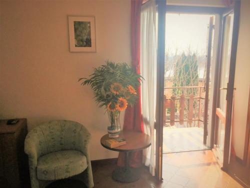 a living room with a chair and a vase of flowers at Camping Hotel Au Lac De Como in Sorico