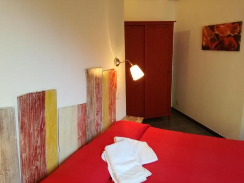 un letto rosso in una stanza con dipinti alle pareti di Appartamento Via Signorini a Riomaggiore