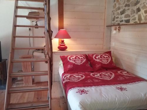 a bedroom with a bunk bed with a ladder and a lamp at Gallinette in Rigaud