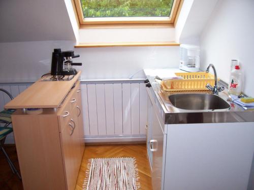a small kitchen with a sink and a window at Júlia Vendégház in Zalakaros