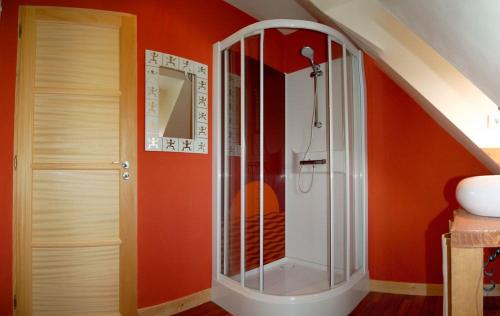 a bathroom with a shower with an orange wall at Les longères du Trieux in Lézardrieux