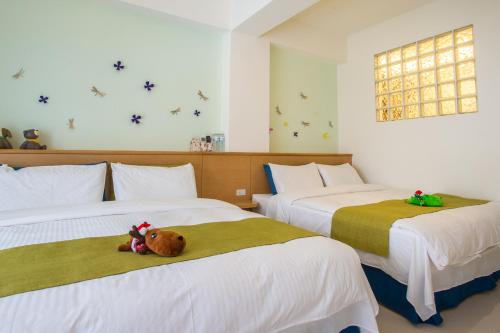 ein Schlafzimmer mit 2 Betten und einem Teddybär auf dem Bett in der Unterkunft I Stay B&B in Hualien