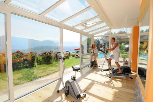 a group of people exercising in a gym with windows at Steinegger in Appiano sulla Strada del Vino