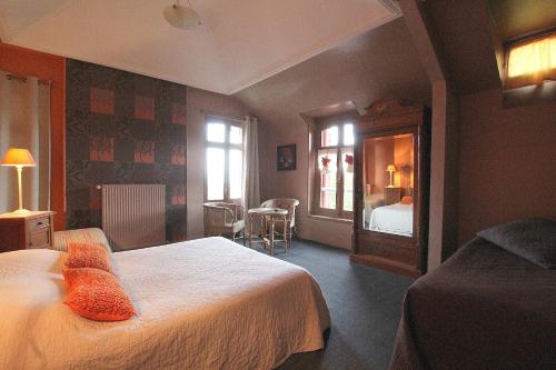 a hotel room with a bed and a mirror at La Villa des Rosiers in Cricquebœuf