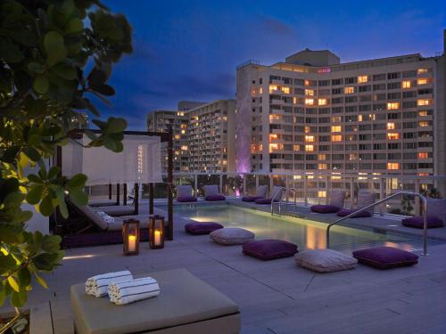 a rooftop patio with a pool and a building at ABAE Hotel by Eskape Collection in Miami Beach