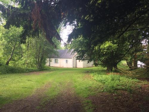 uma casa no meio de um campo com árvores em Pond Cottage em Covington