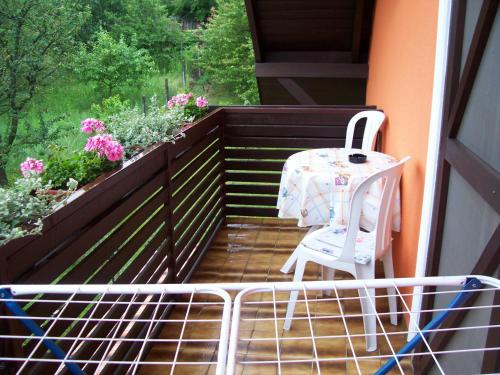 a table and a chair on a balcony with flowers at Júlia Vendégház in Zalakaros