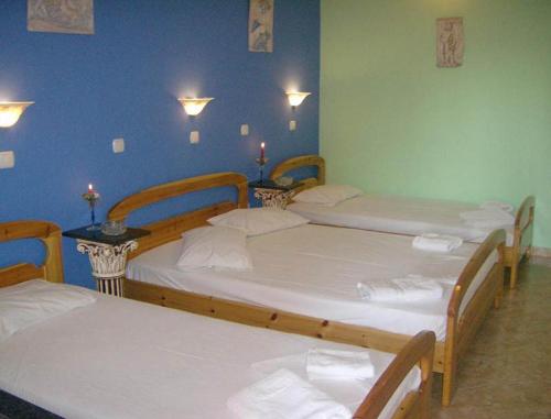a room with three beds and two tables with candles at Sweet Home in Karterados
