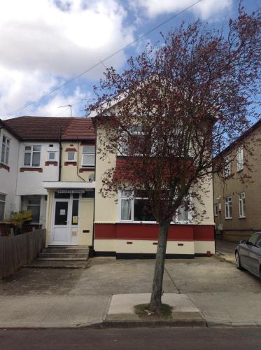 una casa con un árbol delante en Repton Private Hotel, en Romford