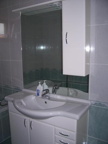 a bathroom with a white sink and a mirror at Júlia Vendégház in Zalakaros