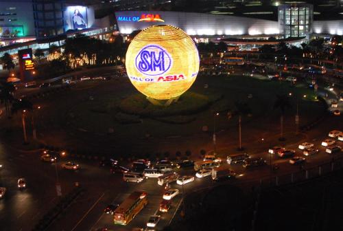 a balloon is flying over a busy city at night at Premiere Haven MOA Staycation in Manila