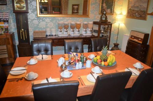 a table with a bowl of fruit on it at The Quaich B&B in Inverness