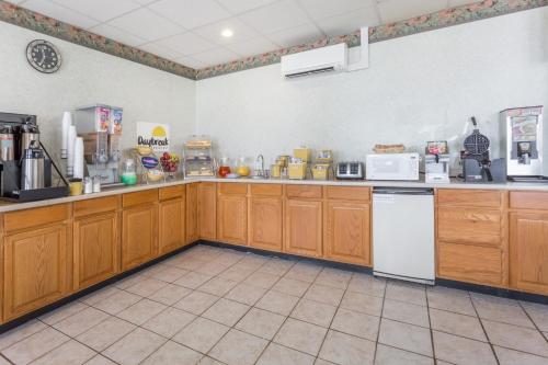 Days Inn by Wyndham Bedford في بيدفورد: مطبخ كبير مع خزائن وأجهزة خشبية
