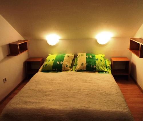 a bedroom with a large bed with green pillows at Willa Korweta in Władysławowo