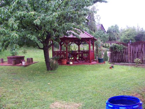 a gazebo in a yard with a tree at Júlia Vendégház in Zalakaros