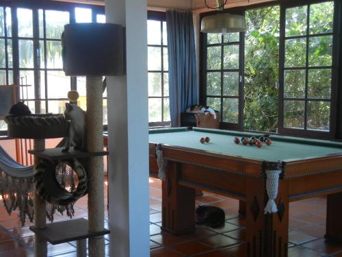 a room with a pool table and a room with windows at The Cats' House in Florianópolis
