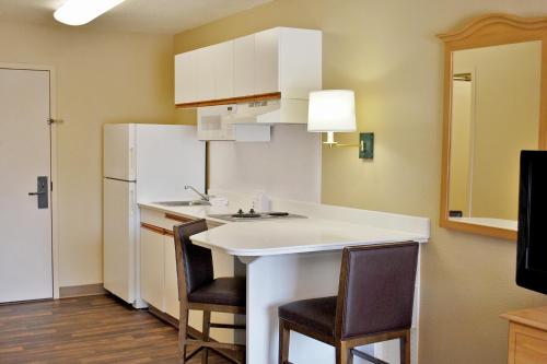 a small kitchen with a white counter and chairs at Extended Stay America Suites - Philadelphia - Horsham - Dresher Rd in Horsham