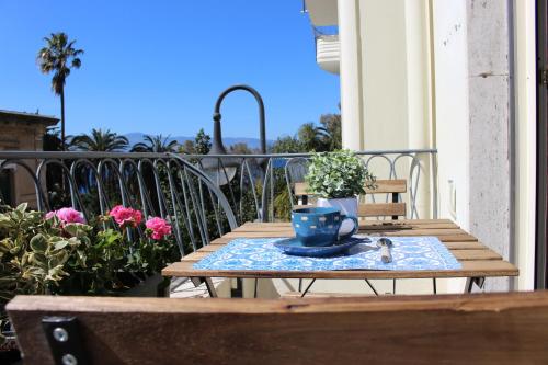 uma mesa de madeira com uma chávena de café azul na varanda em La Casa di Aurora em Reggio di Calabria