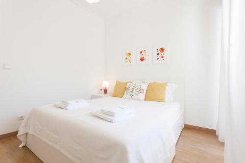 1 dormitorio blanco con 1 cama con sábanas blancas en FLH Marques Bright Apartment, en Lisboa