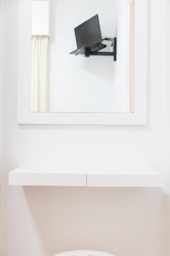 a mirror above a sink with a laptop on a shelf at Rey Fernando in Santiago de Compostela