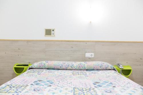a bedroom with a bed with a quilt on it at Rey Fernando in Santiago de Compostela