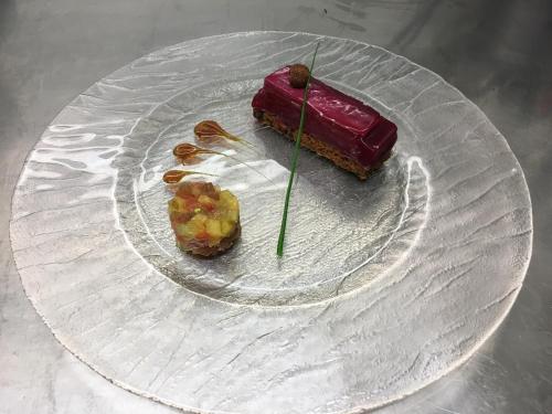 a glass plate with a piece of food on it at Logis Le Midland in Vichy
