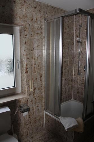 a bathroom with a shower with a glass door at Gasthaus Mösle in Reute