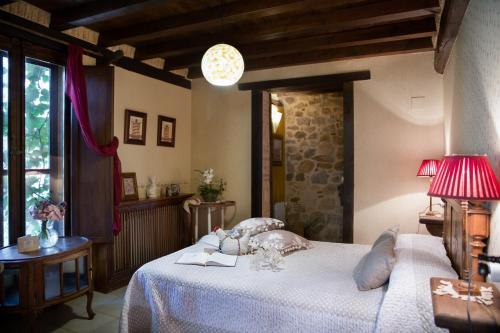 a bedroom with a bed and a lamp and a window at Casa Rural la Casa del Bosque in Navaconcejo