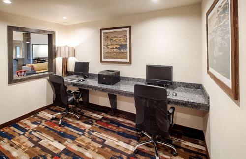 a hotel room with a desk with a computer and chairs at Red Lion Ridgewater Inn & Suites Polson in Polson