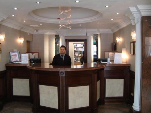 a man sitting at a bar in a restaurant at Royal Eagle Hotel in London