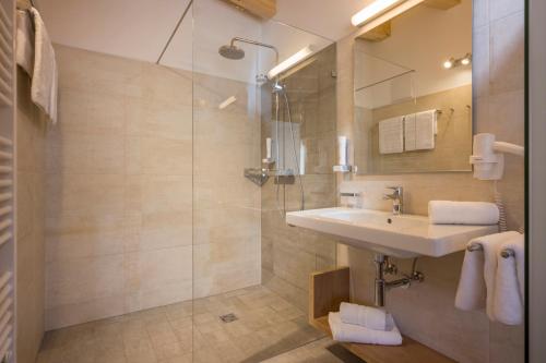 a bathroom with a sink and a shower at Hotel Post in Westendorf