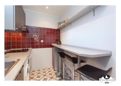 a kitchen with a counter and a sink in it at Beco das Flores Typical Apartment in Lisbon