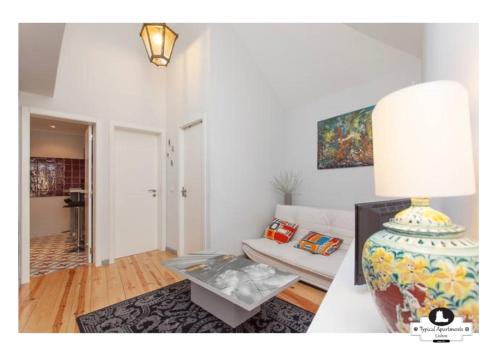 - un salon avec un canapé et une table dans l'établissement Beco das Flores Typical Apartment, à Lisbonne