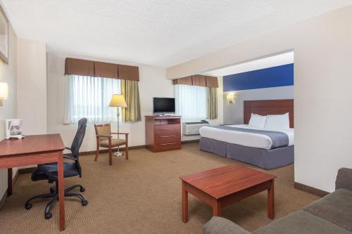 a hotel room with a bed and a desk at Baymont by Wyndham Dubuque in Dubuque
