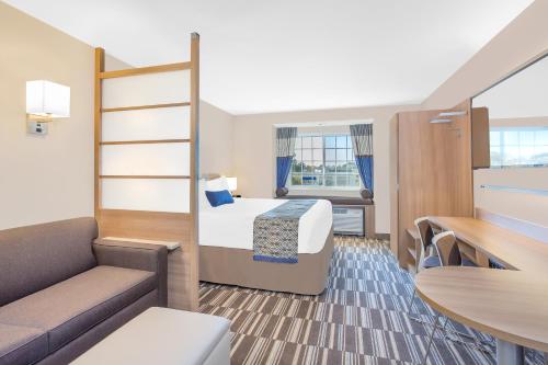 a hotel room with a bed and a couch at Microtel Inn & Suites by Wyndham Ocean City in Ocean City